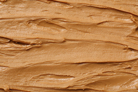 Tasty peanut butter as background, top view