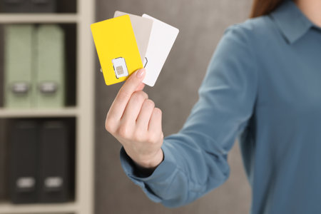 Woman holding SIM cards indoors, closeup viewの写真素材