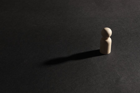 Loneliness concept. Human figure alone on black background. Space for textの写真素材