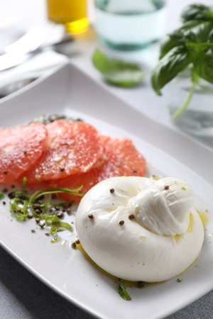 Delicious burrata cheese, grapefruit and spices on table, closeupの写真素材