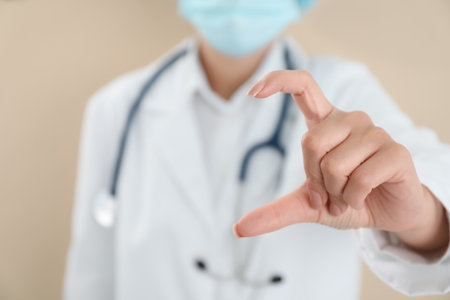 Doctor holding something on beige background, closeupの写真素材