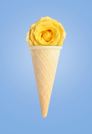 Ice cream cone with rose flower on pale blue backgroundの写真素材