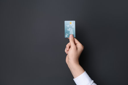 Man holding credit card on black background, closeupの写真素材