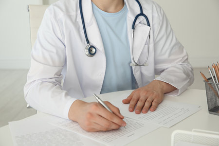Doctor with stethoscope at white table in hospital, closeupの写真素材