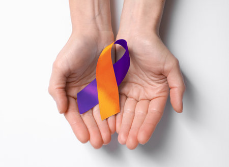 World Psoriasis Day. Woman with orange and orchid ribbon as symbol of support on white background, top viewの写真素材