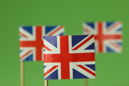 Small paper flags of United Kingdom on green background, selective focusの写真素材