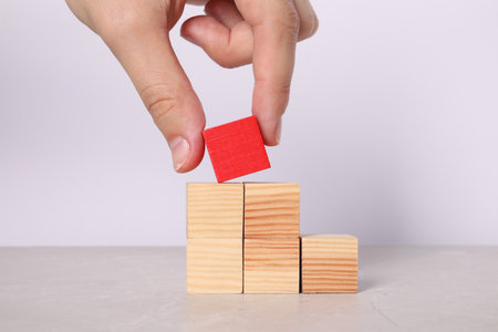 Woman with wooden cubes at light table, closeup