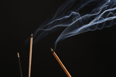 Aromatic incense sticks smoldering on black backgroundの写真素材