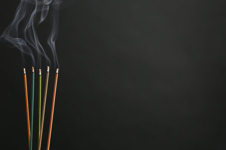 Aromatic incense sticks smoldering on black background. Space for textの写真素材