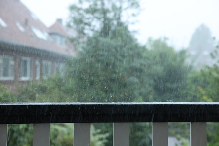 View on buildings and trees from balcony on rainy dayの写真素材