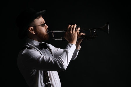 Professional musician playing trumpet on black backgroundの写真素材