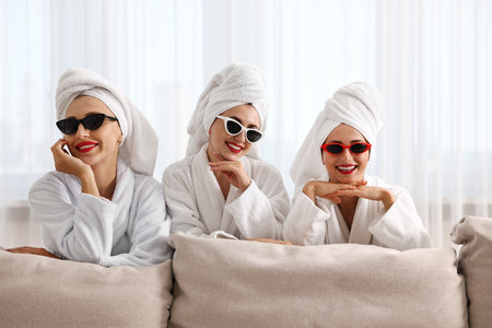 Happy friends in bathrobes with sunglasses indoors. Spa partyの写真素材