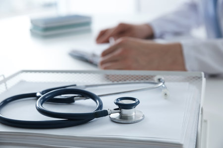 Doctor at white table in hospital, focus on medical stethoscopeの写真素材