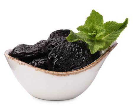 Tasty dried plums (prunes) and mint leaves on white backgroundの写真素材