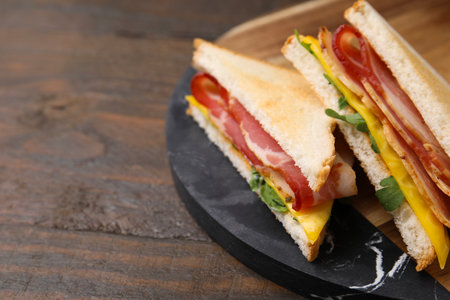 Delicious sandwiches with bacon on wooden table, closeup. Space for textの写真素材