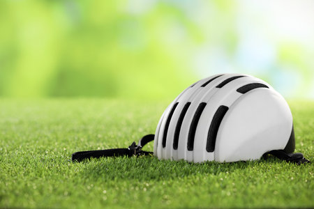 White protective helmet on green grass, space for textの写真素材