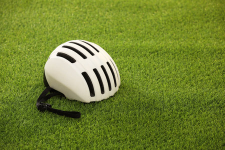 White protective helmet on green grass, space for textの写真素材