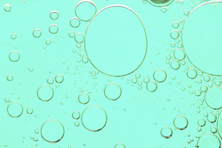 Turquoise cosmetic oil with bubbles, closeup view