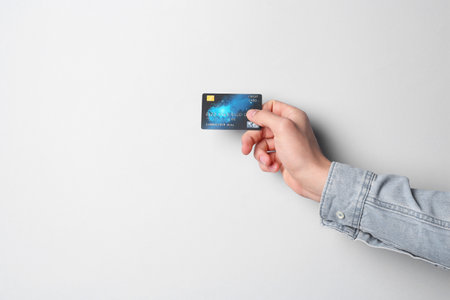 Man holding credit card on light gray background, closeupの写真素材