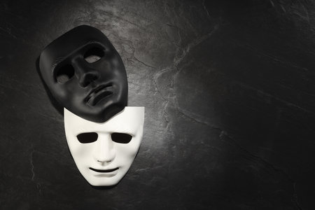 Plastic face masks on black slate surface, top view and space for text. Theatrical performanceの写真素材