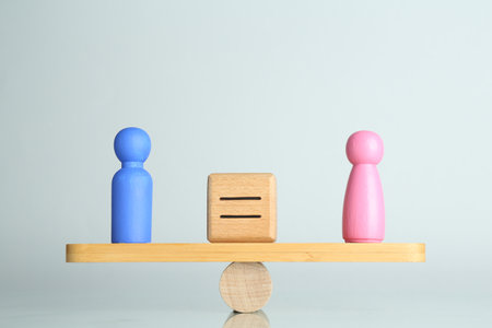 Gender equality concept. Male and female figures on scales against light backgroundの写真素材