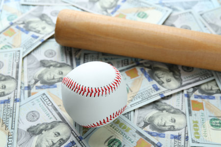Baseball ball and bat on dollars bills, closeupの写真素材