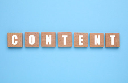Word Content made of wooden cubes with letters on light blue background, top viewの写真素材