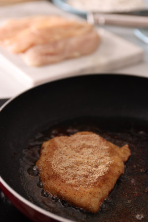 Cooking schnitzel in frying pan on stove, closeupの写真素材