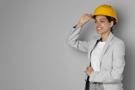 Engineer in hard hat on grey background, space for textの写真素材