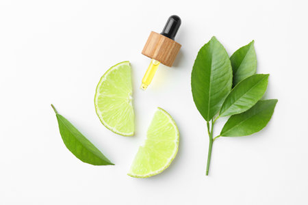 Pipette of essential oil, lime and green leaves on white background, flat lay