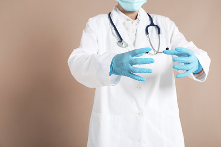 Doctor holding something on beige background, closeupの写真素材