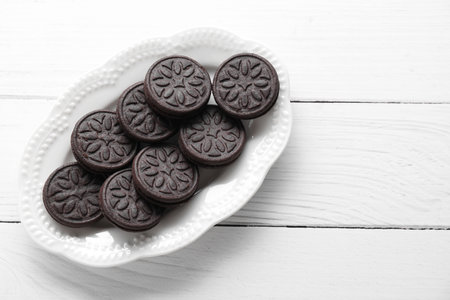 Many tasty sandwich cookies on white wooden table, top view. Space for textの写真素材