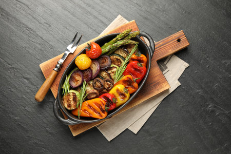 Delicious grilled vegetables in baking dish served on grey textured table, flat layの写真素材