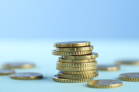 Stack of euro coins on light blue background, closeupの写真素材