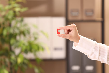 Woman holding SIM card indoors, closeup. Space for text