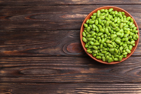 Raw green edamame soybeans in bowl on wooden table, top view. Space for textの写真素材