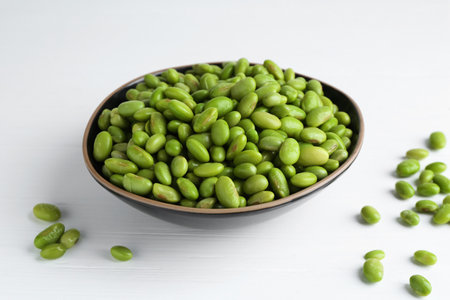 Fresh edamame soybeans in bowl on white wooden table, closeupの写真素材