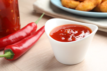 Spicy chili sauce in bowl on wooden table, closeupの写真素材