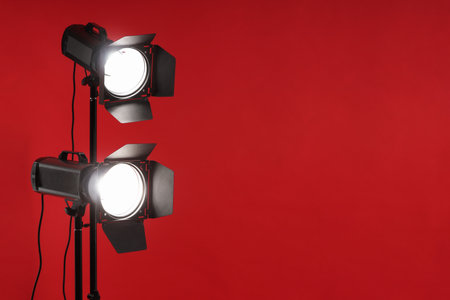 Red photo background and professional lighting equipment in studio, space for textの写真素材