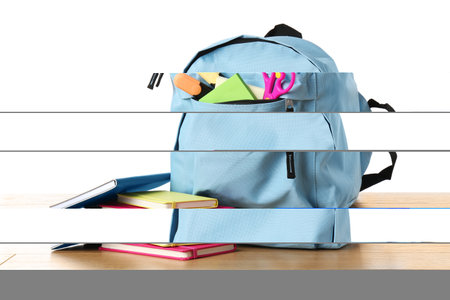 Backpack with different school stationery on wooden table against white background