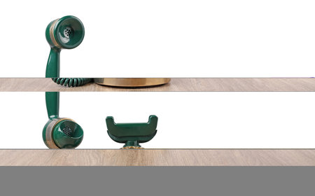 Green vintage corded telephone on wooden table against light background, space for text