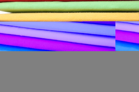 Stack of clean colorful t-shirts as background, closeupの写真素材