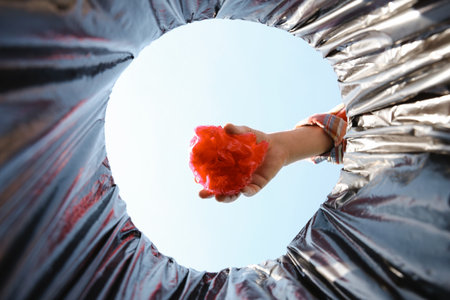 Man garbage throwing into trash bin outdoors, bottom viewの写真素材