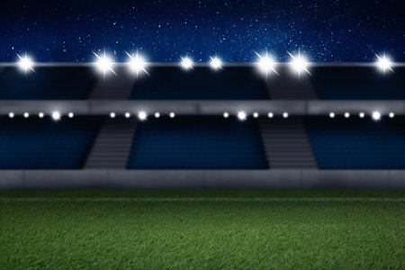 Football stadium with seats, illumination and green grassの写真素材