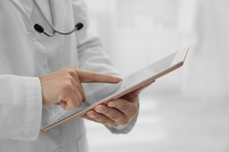 Doctor with tablet in clinic, closeup viewの写真素材