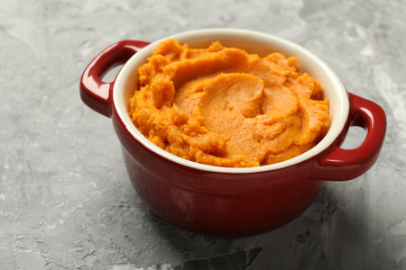 Delicious mashed sweet potatoes in pot on gray table, closeupの写真素材