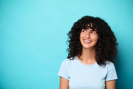 Happy young woman on light blue background, space for text. Dental veneersの写真素材