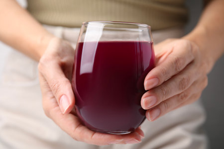 Woman with glass of fresh beet juice, closeup