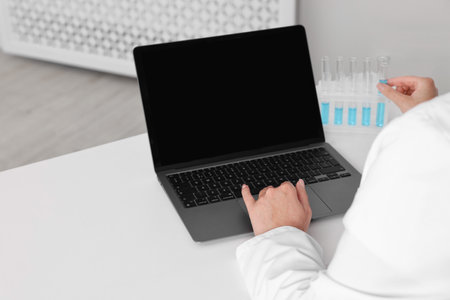 Doctor with laptop at table in clinic, closeup viewの写真素材