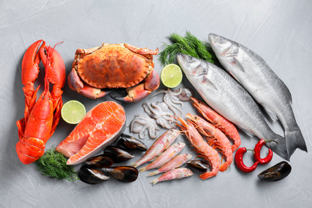 Many different sea food on gray textured table, flat layの写真素材
